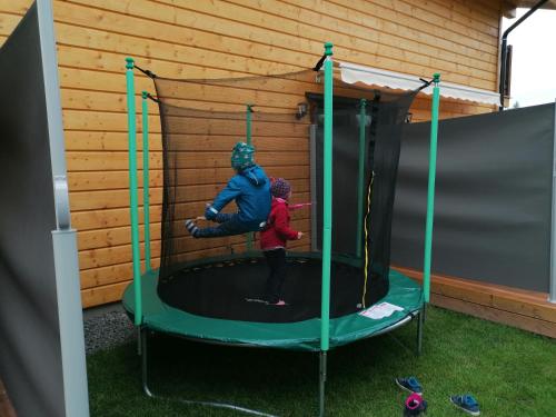 a man and a child playing on a trampoline at Chata Klaudi a Vilko in Veľký Slavkov