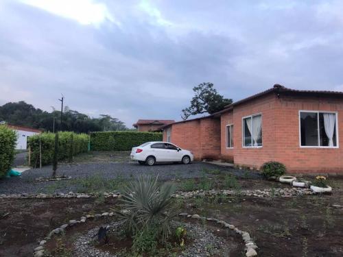 une voiture blanche garée devant une maison en briques dans l'établissement amplias zonas verdes, tranquilidad, seguridad 24/7, à Pereira