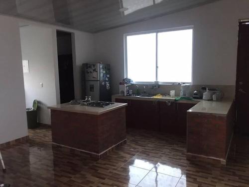 a large kitchen with a large window and a counter top at amplias zonas verdes, tranquilidad, seguridad 24/7 in Pereira