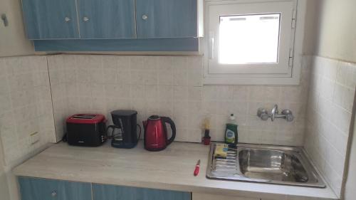 a kitchen counter with a sink and a window at Boho Studios Liapades - Near restaurants, bus and beaches in Liapades