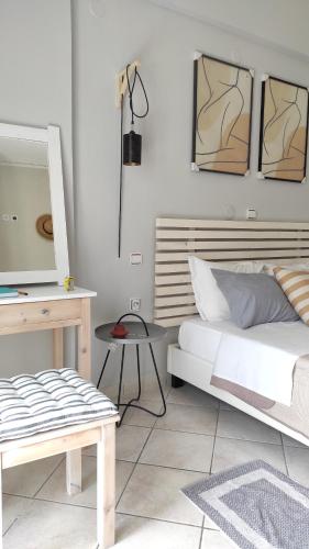 a bedroom with a bed and a table and a tv at Boho Studios Liapades - Near restaurants, bus and beaches in Liapades
