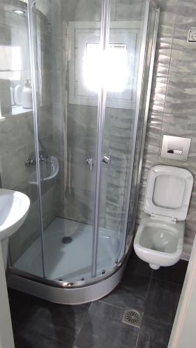 a bathroom with a shower and a toilet and a sink at Boho Studios Liapades - Near restaurants, bus and beaches in Liapades