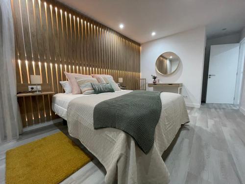 1 dormitorio con 1 cama grande y pared de madera en Oktheway Old Town en A Coruña