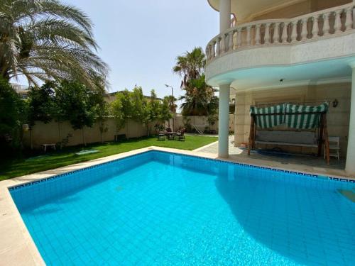 a swimming pool in front of a house at Paradise Villa - King Mariout in King Mariout