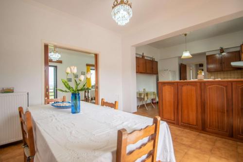 a dining room table with a vase of flowers on it at Kypseli Farmhouse in Kipseli