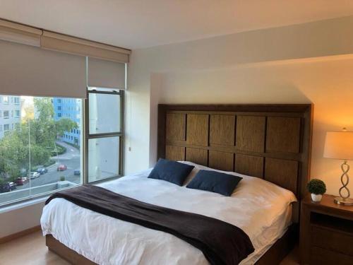 a bedroom with a large bed with a large window at Hermoso Depto de 3 rec ubicado corazón de Santa Fe in Mexico City