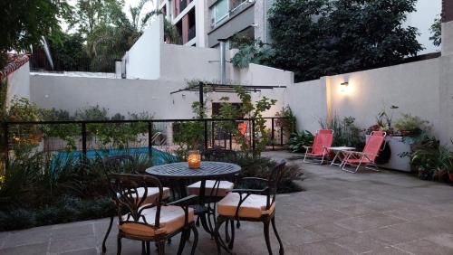 a patio with a table and chairs and a fence at Rawson 3840 Alquiler de Suites La Lucila, Vicente Lopez, Buenos Aires in La Lucila