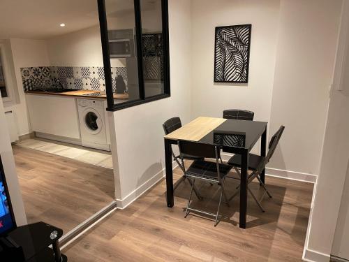 une salle à manger avec une table et des chaises ainsi qu'un lave-linge dans l'établissement Le Black & White, hyper centre - paisible- wifi HD- NETFLIX- proche gare -Ideal couple et business, à Niort