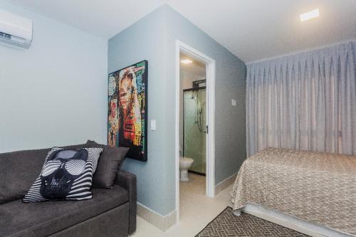 ein Schlafzimmer mit einem Sofa und einem Bett in einem Zimmer in der Unterkunft Flat em Lagoa Nova, Mobiliado e Aconchegante in Natal