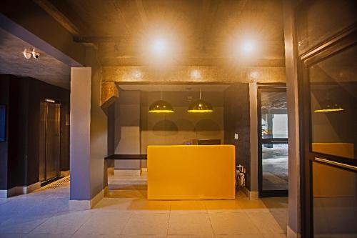 a yellow table in a room with lights on the ceiling at Flat em Lagoa Nova, Mobiliado e Aconchegante in Natal