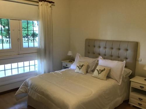 ein Schlafzimmer mit einem großen weißen Bett mit zwei Kissen in der Unterkunft Casa al rio in San Pedro