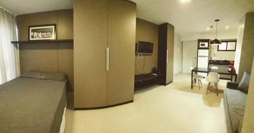 a bedroom with a bed and a room with a desk at Flat em Lagoa Nova, Mobiliado e Aconchegante in Natal