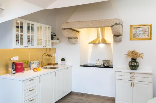 una cucina con mobili bianchi e un lavandino di Dubrovnik Old Town Apartments a Dubrovnik