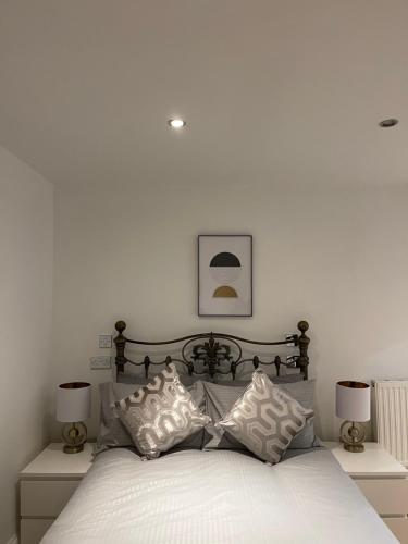 a bedroom with a bed with white sheets and pillows at Luxury 2-bedroom apartment in the heart of Manchester city centre in Manchester