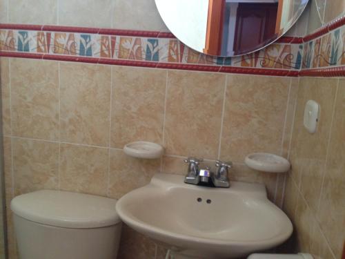 ein Badezimmer mit einem WC, einem Waschbecken und einem Spiegel in der Unterkunft Hotel Vans Valledupar in Valledupar