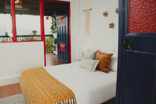 ein Schlafzimmer mit einem weißen Bett und einer blauen Tür in der Unterkunft Hacienda Boutique Santa Rosanna in Santa Rosa de Cabal