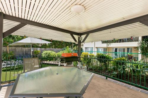 a patio area with a bench and a skateboard at Reef Gateway Apartments in Cairns