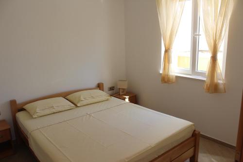 1 dormitorio con 1 cama grande y ventana en Apartments Villa Eva, en Slano