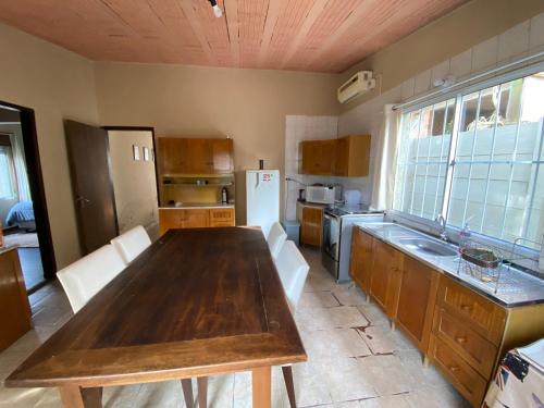 a kitchen with a wooden table in a room at Casa agradável com lareira in Chuí