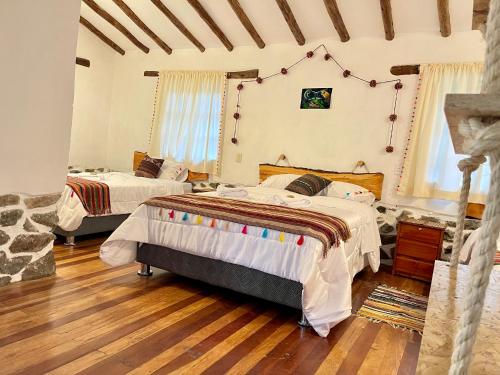 a bedroom with two beds in a room at Hotel Highgarden Ollantaytambo in Ollantaytambo