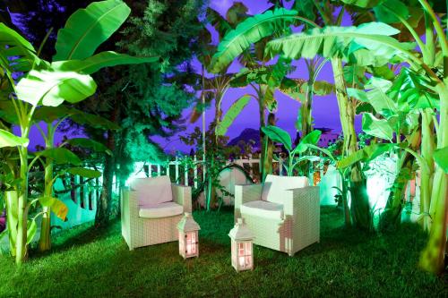 a group of chairs sitting in the grass with lights at Viaros Hotel Apartments in Tolo