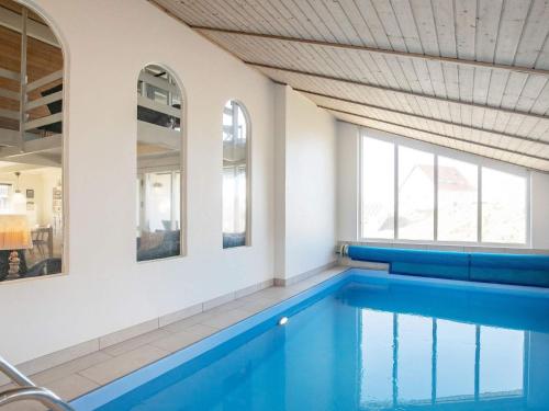 a swimming pool with blue seats and windows at 10 person holiday home in Thisted in Nørre Vorupør