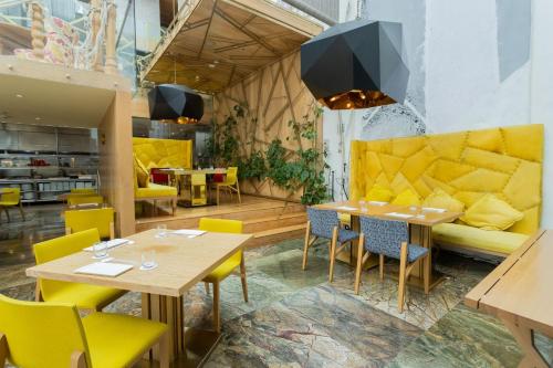 a restaurant with yellow chairs and tables and a couch at Camino Real Polanco Mexico in Mexico City