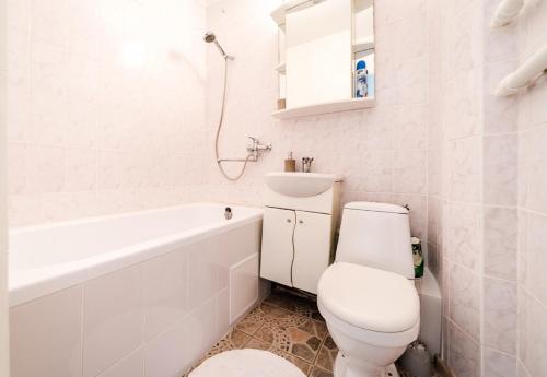 Baño blanco con aseo y lavamanos en Nice Apartment in Riga Suburbs, en Riga