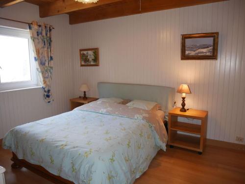 a bedroom with a bed and two tables with lamps at Granite stone house with fireplace, Plouguerneau in Plouguerneau