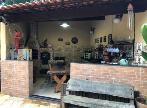a kitchen with a table and a brick wall at Casa de campo com piscina em Paty do alferes in Paty do Alferes