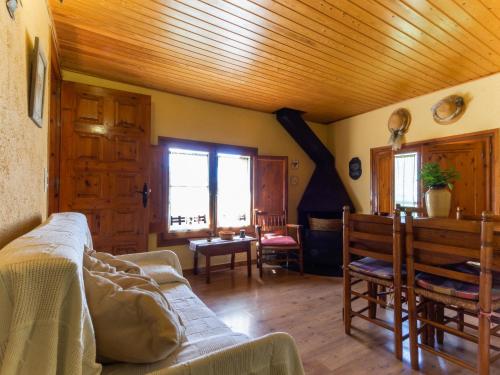 a living room with a couch and a wooden ceiling at Masia Can Constans in Queralbs