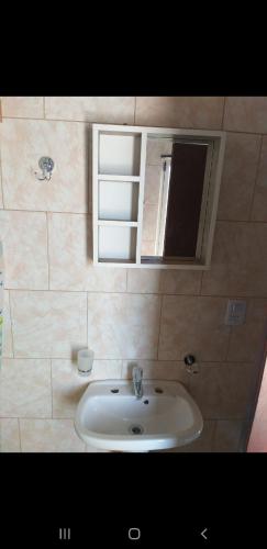 a bathroom with a sink and a mirror at La Peninsula in Neuquén