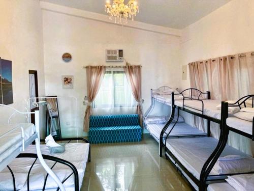 a room with four bunk beds and a chandelier at BALAI BANAHAW Vacation Farm and Private Resort in Lucban