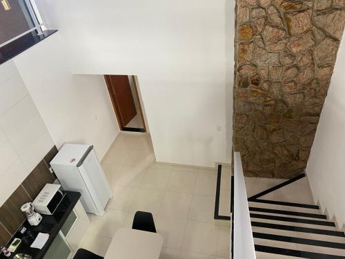 a room with a staircase and a stone wall at Souza Reis Apart - Unidade 2 in São Thomé das Letras