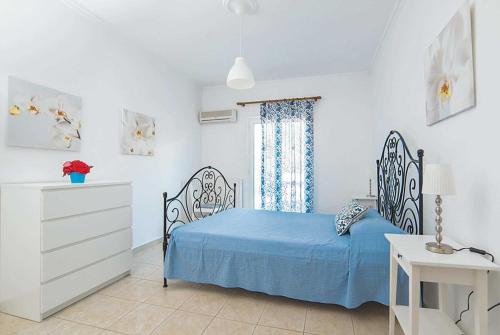 a bedroom with a blue bed and a window at Villa Lilly in Kypseli