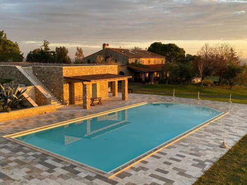 a swimming pool in front of a house at Belvilla by OYO Podere San Giovanni ventisei in Chianni