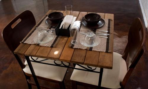 a wooden table with plates and glasses on it at Pousada Sr. Ivan in Serra do Cipo