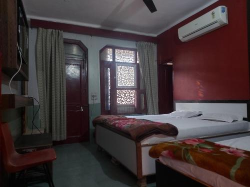 a hotel room with two beds and a window at Hotel Vijay laxmi in Haridwār