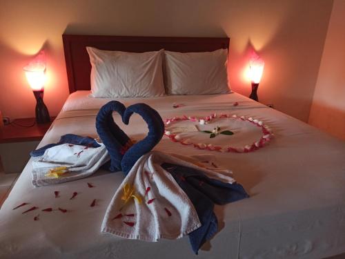 a bed with two swans making a heart at Mama Bella's Retreat in Senggigi 