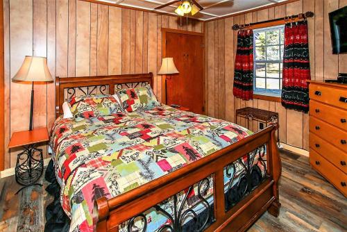 a bedroom with a bed in a room with wooden walls at Frank's Old Bear-149 by Big Bear Vacations in Big Bear Lake
