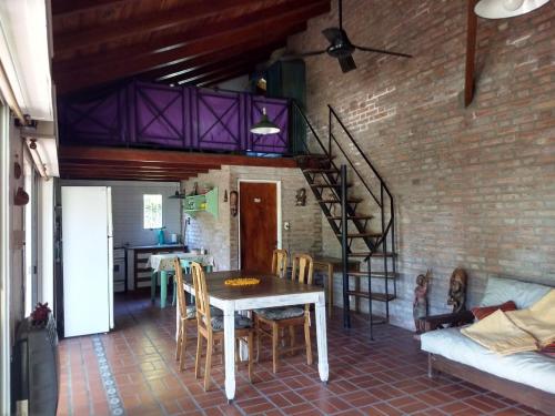 a dining room with a table and a brick wall at Las Calandrias in Funes