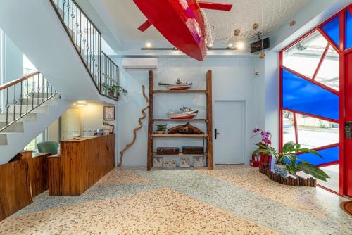 a living room with a staircase and a red surfboard at 睡海邊包棟民宿 sleep on beach B&B in Suao