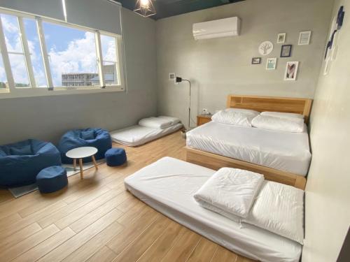 1 dormitorio con 2 camas, mesa y ventana en Liuqiu Backpackers Hostel, en Xiaoliuqiu