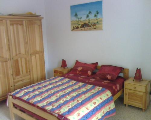 a bedroom with a bed and a painting on the wall at Excellente Appartement Entre Monastir Et Sousse in Sahline