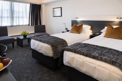 a hotel room with two beds and a table at Bay Plaza Hotel in Wellington