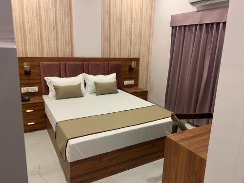 a bedroom with a bed with a wooden headboard at Hotel Mumbai House-LIG Behind CHL Hospital in Indore