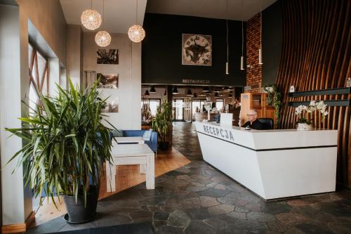 a lobby of a restaurant with a counter and potted plants at Hotel nad Wisłą in Tczew