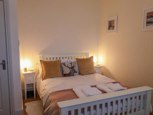a bedroom with a white bed with towels on it at Rydal Suite in Ambleside