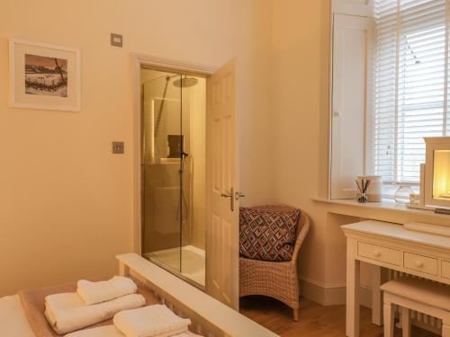 a bathroom with a shower with a mirror and a chair at Rydal Suite in Ambleside