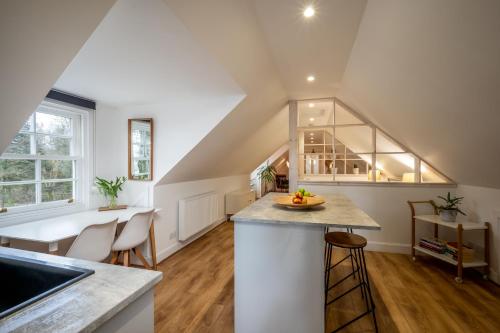 an attic kitchen with a counter and stools at Modern and Stylish WoodHous in Forfar